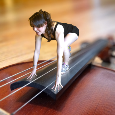 A photo of Robyn in runners starting pose photoshopped onto the fingerboard of a viola